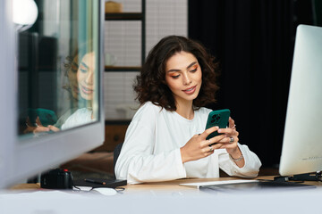 Young woman with curly hair enjoys remote work while connecting digitally at home office