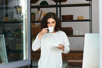 Freelancer enjoying coffee while working from home in a cozy space