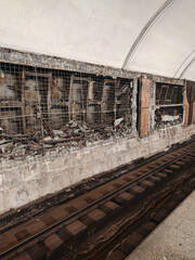 Abandoned subway station with exposed walls and debris near train tracks showcasing urban decay
