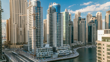 Dubai Marina at evening timelapse with trails of boats on the water and cars traffic, Dubai, UAE