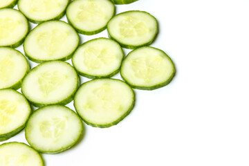 Background created from green ripe natural organic cucumber sliced into circles on white background
