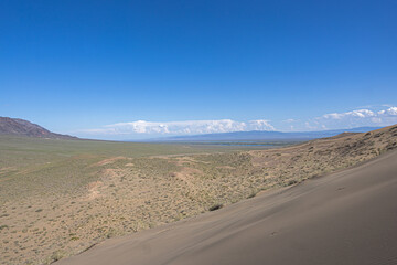 A vast sandy desert landscape with dunes