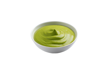 a bowl of green sauce on a white surface