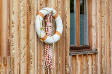 A lifebuoy is hanging on a wooden wall, a close-up photo