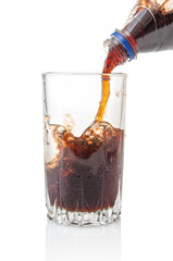 Pouring cola from bottle into glass isolated on white background