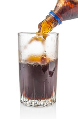 Pouring cola from bottle into glass isolated on white background