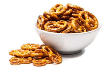 Small traditional beer pretzels with salt in a white ceramic bowl isolated on white background