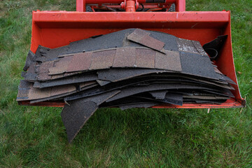 Old Asphalt Shingles in Loader Bucket After Roof Tear-Off