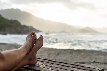 Legs of woman relaxing on tayrona national park beach, colombia, enjoying vacation lifestyle