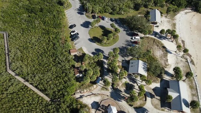 Drone flies south high above Robert K Rees Memorial Park in bird's eye view of the beach and mangroves in Florida, USA