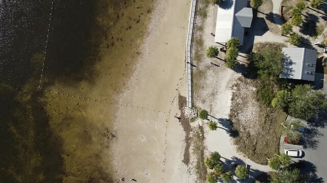 Drone north along beach at Robert K Rees Memorial Park in bird's eye view on sunny day in Florida, USA