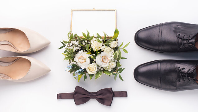 Bride and groom accessories. Wedding shoes, bow-tie and bouquet on white background, panorama