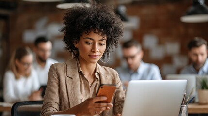 Young African American business woman using smartphone sitting in office at busy team meeting. Female manager employee working on phone and laptop technology corporate group briefing., no logos, no b