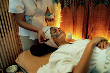 Serene ambiance of spa salon, woman customer indulges in rejuvenating with charcoal face cream...