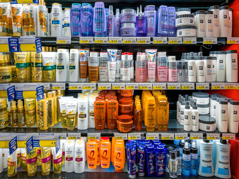 Italy - July 22, 2025: Oreal and Pantene brand shampoo and conditioner and hair -care products in packs of various types displayed on shelves for sale in Italian supermarket