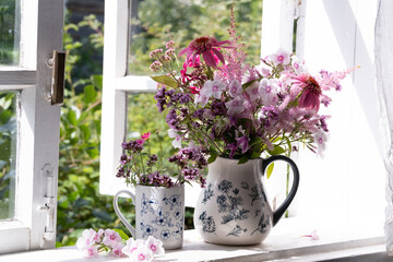 pink flowers in a vase on window sill