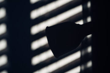A light is turned off and the shadow of the light is cast on the wall