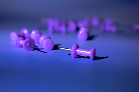 Scattered purple push pins on a cool blue surface. Soft shadows and clean contrast evoke calm productivity. Great for planners, office blogs, or educational content.