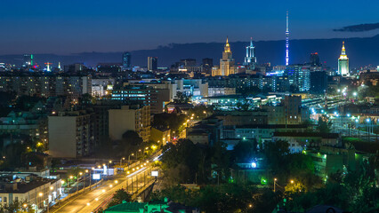 Fototapeta premium Ostankino tv tower and stalin skyscrapers near railway station night timelapse. Moscow, Russia