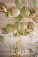 background for a holiday in beige and green tones consisting of balloons