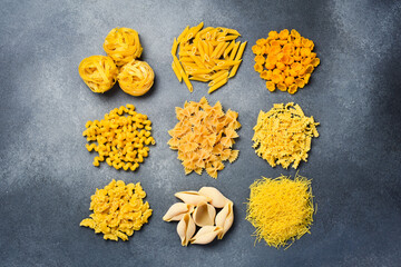 Various pasta on concrete background. Italian food culinary concept. Top view.