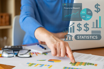 Businesswoman pointing at financial statistics and charts, analyzing company performance using...