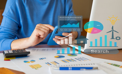 Businesswoman is using smartphone and laptop for analyzing financial charts, business performance, and making strategic decisions based on market analytics and data intelligence