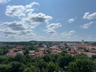 Fototapeta premium Scenic View of Vilnius Old Town from Gediminas Tower on a Clear Summer Day – Red Rooftops, Historic Architecture, and Blue Sky with Clouds Over the Capital of Lithuania