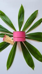 Obraz premium Pink candle tin with green leaves and matches still life photography stock image photo