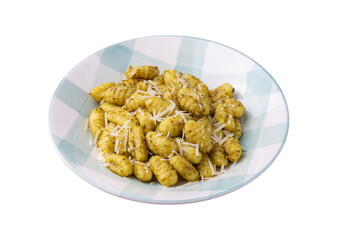 Italian pasta gnocchi on a plate with pesto sauce and parmesan cheese isolated over white background