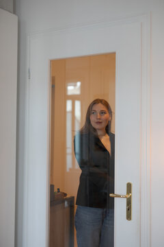 young woman standing in front of door