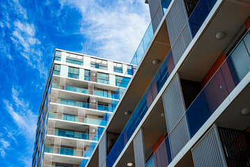 Modern Multi-Story Residential Building with Vibrant Facade, Large Balconies, and Scenic Urban...