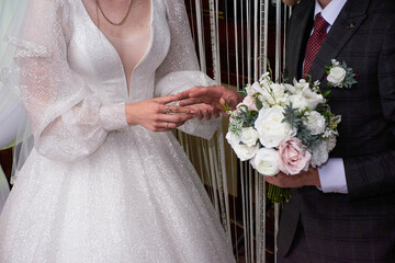 Young couple at the wedding exchanges engagement rings