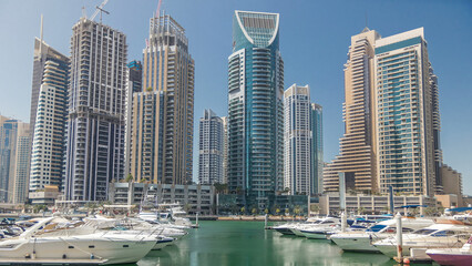 Panoramic view with modern skyscrapers and water pier with yachts of Dubai Marina timelapse, United Arab Emirates