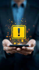 Yellow warning sign with exclamation mark floating above smartphone held by person in suit alert notification