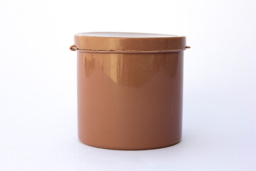 A brown tube container for storing women's powder sponges, isolated on white background.