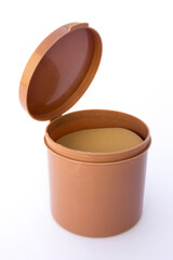 A brown tube container for storing women's powder sponges, isolated on white background.
