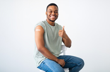 Covid-19 Vaccination. Cheerful Vaccinated Black Man Gesturing Thumbs Up Approving Coronavirus...