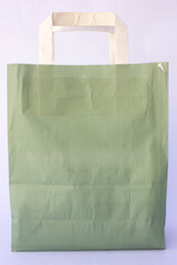 Dark olive green paper shopping bag against white background.