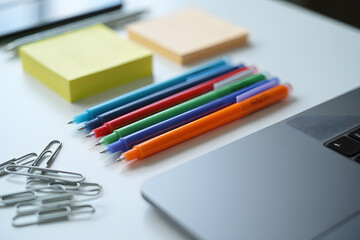 Colorful Pens, Paper Clips, and Sticky Notes on Desk Surface