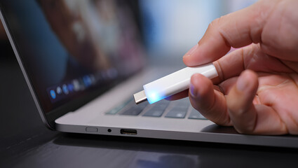 Hand Inserting White USB Drive into Laptop Port