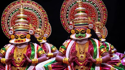 Kathakali dancers in vibrant costumes and elaborate makeup performing traditional indian dance with expressive hand gestures against black backdrop, embodying cultural artistic heritage