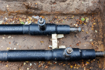 New modern insulated urban pipeline installation construction site  exposed underground pipes in...