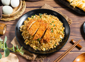 Crispy Chicken Cutlet and Egg Fried Rice on Black Plate with Scallions side view of hong kong food