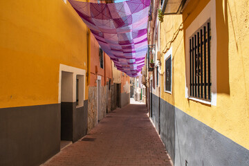 A rural street decorated with a purple awning during the Lavender Festival in Brihuega, Guadalajara province, Spain.