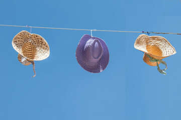 Three straw hats hanging against the blue sky during the lavender festival in Brihuega, Guadalajara province, Spain.