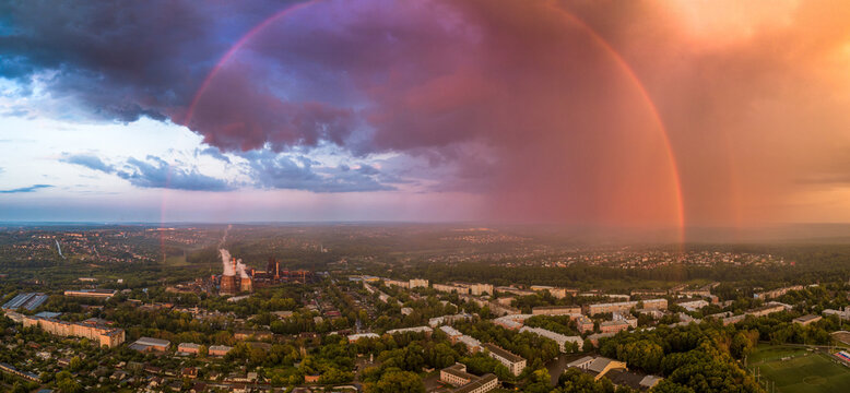 Panoramic Rainbow Over Industrial Cityscape at Sunset