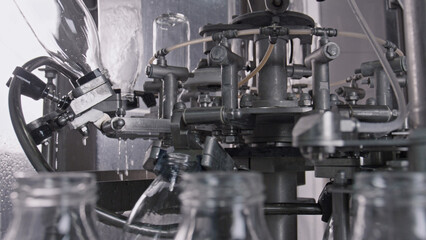 Industrial bottling machine filling glass bottles
