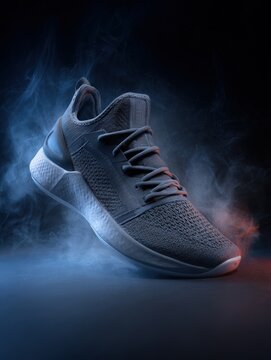 Stylish grey running shoe in dramatic smoke. Perfect for sports, fitness, and fashion advertising. Ideal for websites, social media, and print.
