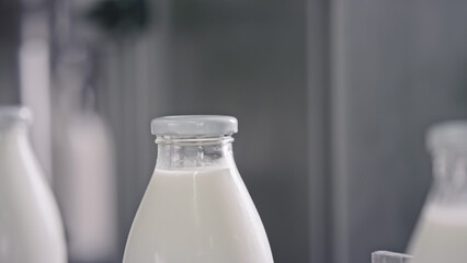 Glass milk bottles waiting on conveyor belt in